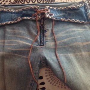 Hipster stone washed jeans. Leather lace up at zip